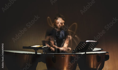 musician playing the drums or timpani with a long exposure capturing movement