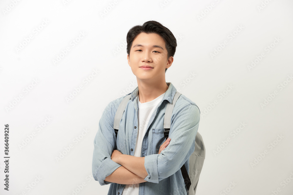 Young guy with a backpack standing with arms crossed isolated on white background Young guy with a backpack standing with arms crossed isolated on white background