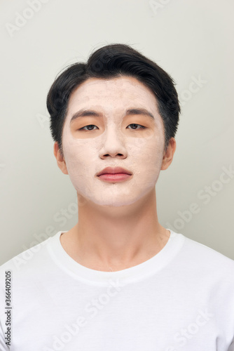 relaxing man with a mud mask on this face