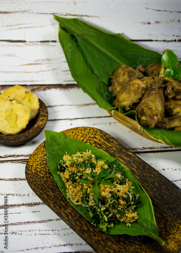 Urap (Indonesian Traditional Food) is a salad dish of steamed vegetables mixed with seasoned & spiced grated coconut for dressing, completed with chicken boiled with coconut milk & fried soybean cake photo