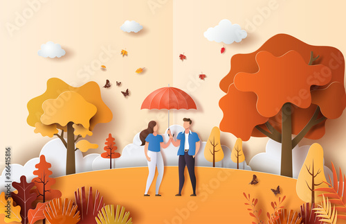Paper art style of autumn landscape with a cute couple in love holding an umbrella in a park.