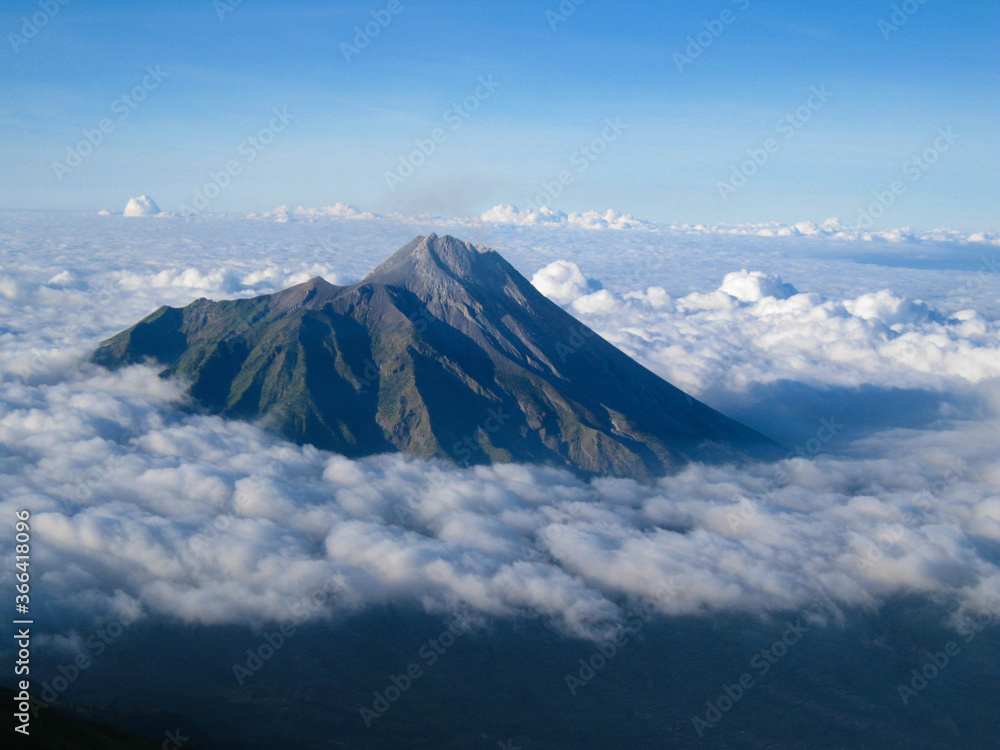 The landscape of Mount Merapi in Central Java, Indonesia, with a background of blue sky, edelweiss trees and clouds