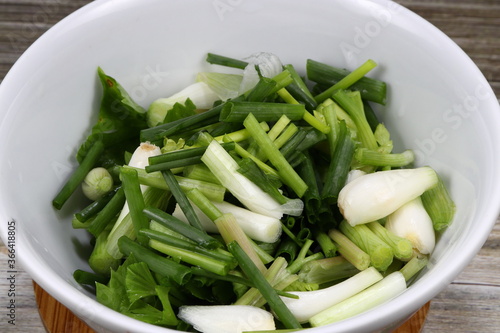 Pile of cutting spring onion in the bowl. Famous traditional herbal vegetable ingredients in Asia restaurant. Preparation food concept. 