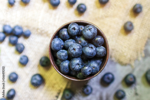 Blueberry antioxidant superfood in a bowl on sackcloth background. Healthy eating and nutrition concept.