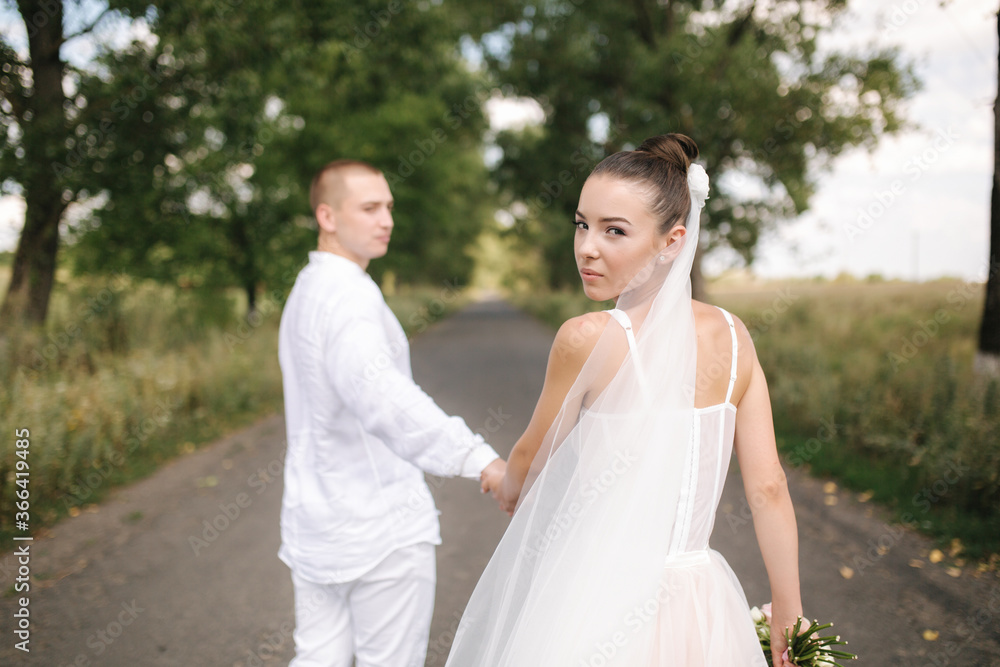 Young and beautiful bride with handsome groom hug each other kiss and smile. Portrait of happy wedding couple Young and beautiful bride with handsome groom hug each other kiss and smile. Portrait of happy wedding couple