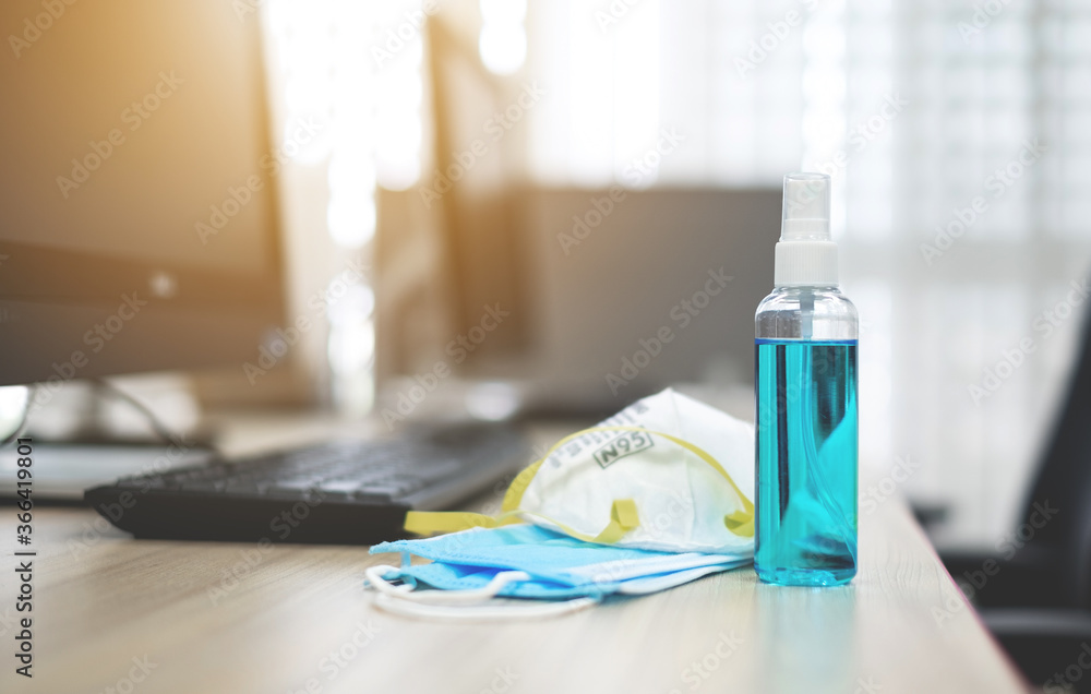 Alcohol spray bottles and medical surgical masks on work desk. Hygiene concept. prevent the spread of germs and bacteria and avoid infections coronavirus or covid-19 Alcohol spray bottles and medical surgical masks on work desk. Hygiene concept. prevent the spread of germs and bacteria and avoid infections coronavirus or covid-19