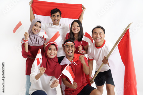 group of indonesian supporter celebrating victory together over white background. people holding flag during independence day of indonesia photo