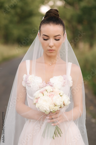 Portrait of elegand bride with bouquet. Young bride outdoors photo