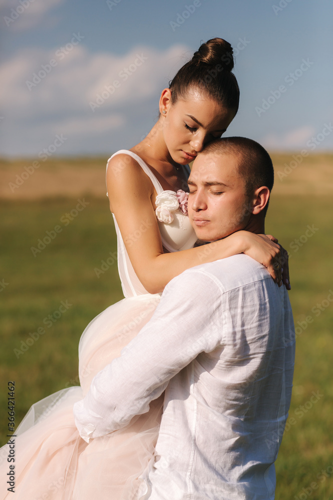 Newlyweds walking in field. Groom hug bride after wedding ceremony Newlyweds walking in field. Groom hug bride after wedding ceremony