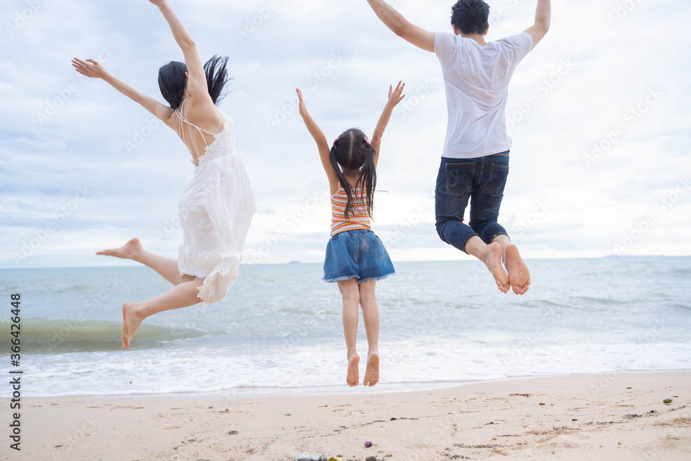 happy family jumping together on the beach happy family jumping together on the beach
