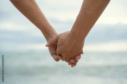 Happy couple holding hands at beach, closeup © Chatsiri