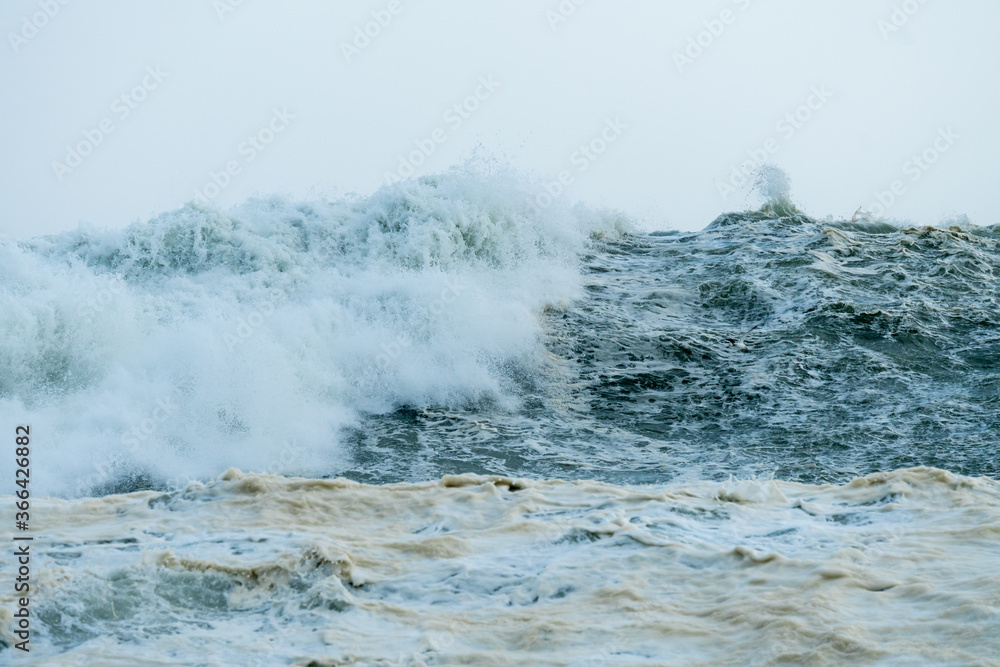 high seas and waves during Spring tide storm crashing down onto each other closeup