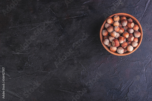 Hazelnuts in a clay bowl, with a place under the text