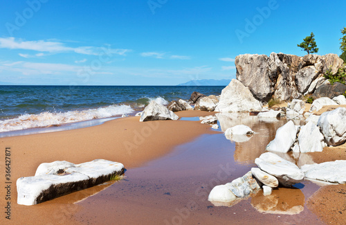 Baikal Lake at sunny day. Beautiful landscape with sandy beach near white stones. Natural background, summer travel