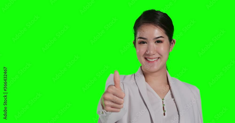 Portrait of businesswoman looking to camera with smile at green background. She showing Portrait of businesswoman looking to camera with smile at green background. She showing