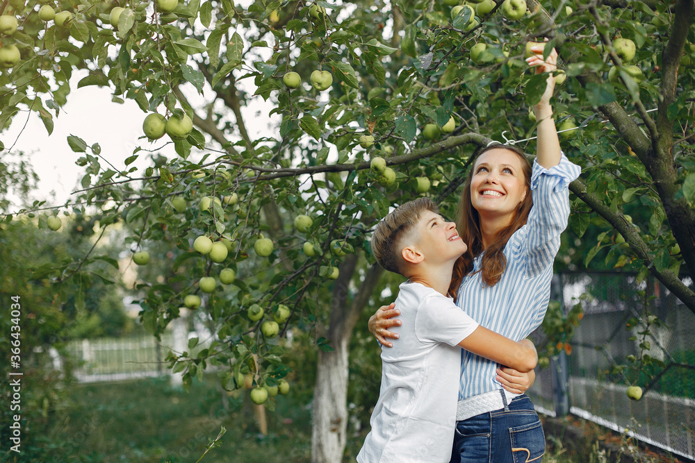 Fashionable mother with son. Family in a spring park. Woman in a blue shirt Fashionable mother with son. Family in a spring park. Woman in a blue shirt