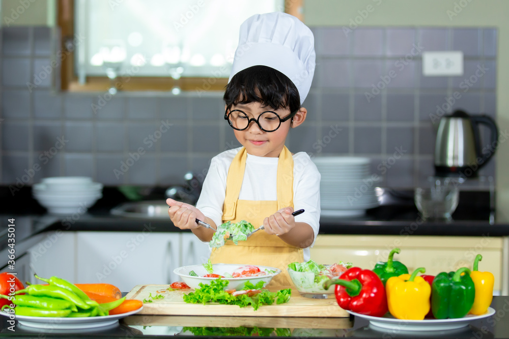 Happy Asian boy having breakfast with preparing food in the kitchen. Happy Asian boy having breakfast with preparing food in the kitchen.