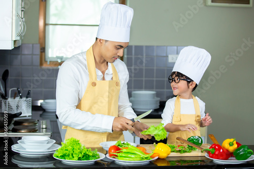Happy family Asian man young father with son boy cooking healthy salad for the first time. first lesson and healthy lifestyle concept.