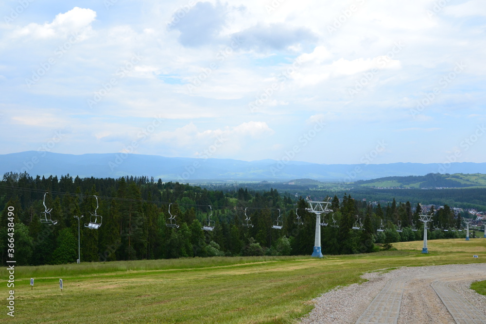 Alpine ski lift (or chairlift) going from Bialka Tarzanska to the station at the top of the mountain Kotelnica. Summer in Podhale, Poland, Europe Alpine ski lift (or chairlift) going from Bialka Tarzanska to the station at the top of the mountain Kotelnica. Summer in Podhale, Poland, Europe