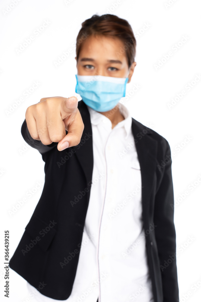 Asian businesswoman wear surgical face mask in formal black suit jacket, point finger to camera, look at camera, studio light isolated on white background, focus at her hand, COVID-19 concept .. Asian businesswoman wear surgical face mask in formal black suit jacket, point finger to camera, look at camera, studio light isolated on white background, focus at her hand, COVID-19 concept ..