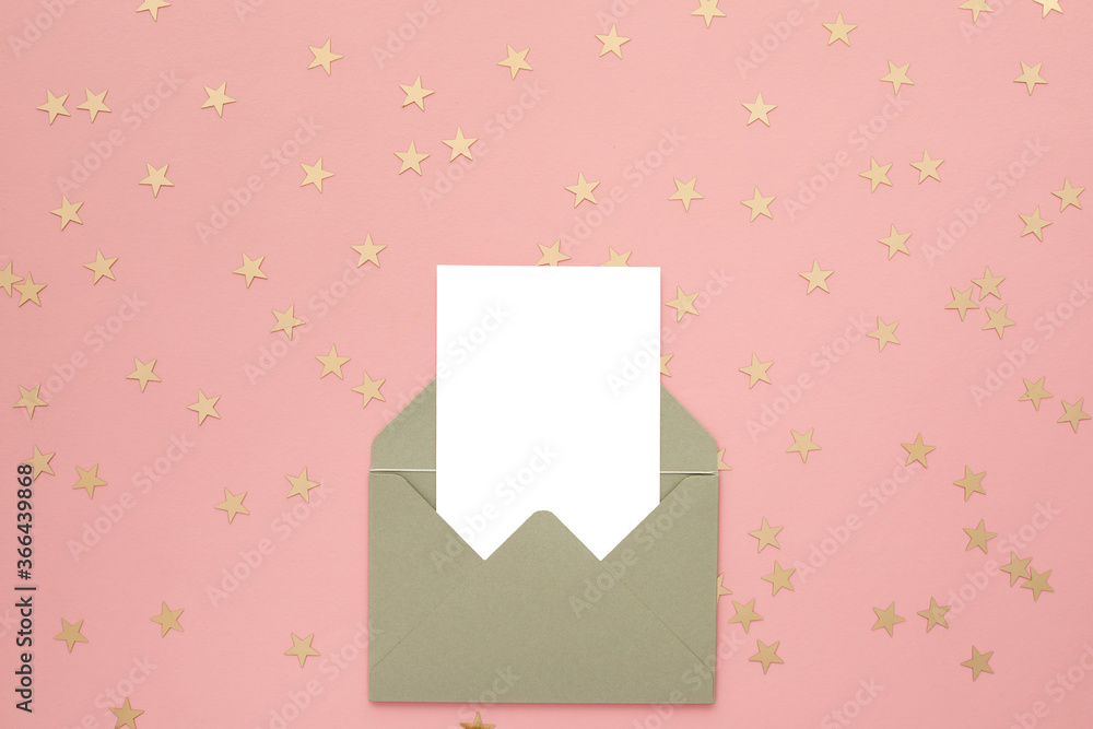 white blank card in envelope on pink background with golden confetti. Holiday mockup. Top view. white blank card in envelope on pink background with golden confetti. Holiday mockup. Top view.