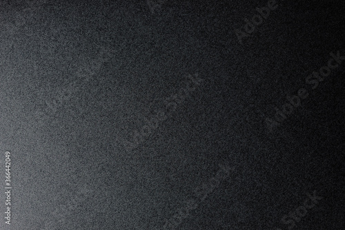 Closeup of black, rough background lit with dim light.