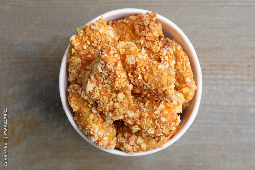Bucket with yummy nuggets on wooden table, top view Bucket with yummy nuggets on wooden table, top view
