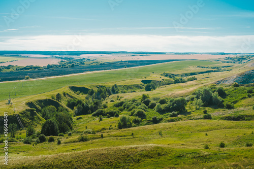 Large panoramic view of the landscape of wheat fields  ears and yellow-green hills  mountain view with lakes