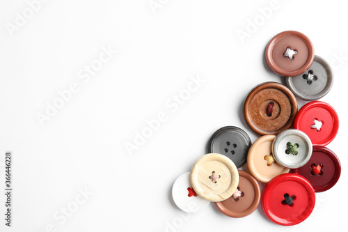 Many colorful sewing buttons on white background, top view