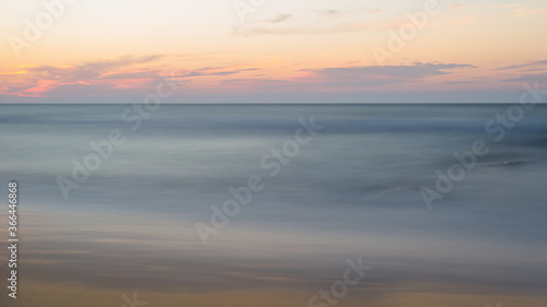 Beautiful blurry sunset at the sea on a hot, summer evening.