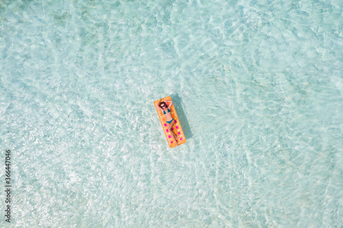 Top above high angle aerial drone view of her she attractive girl floating on rubber mattress in clean clear ocean water enjoying sunny weather taking sun bath tan relax leisure free time #366447046