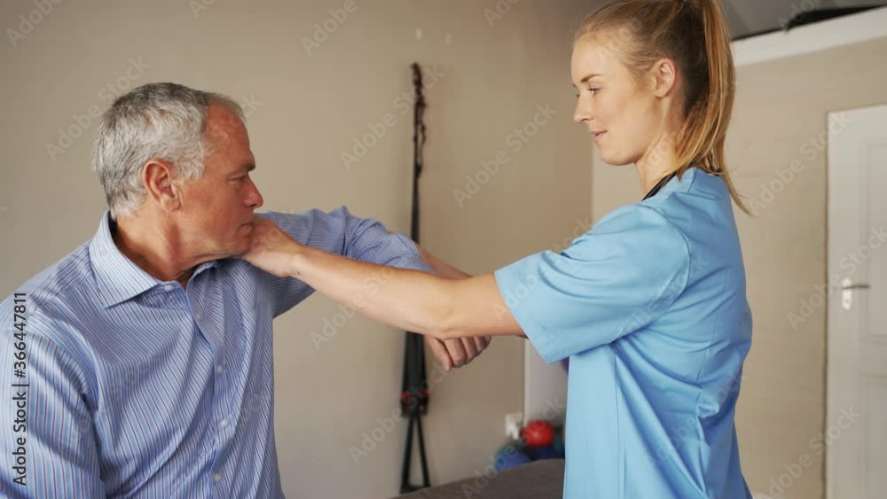 Female doctor or physiotherapist treating male patients shoulder, ticking checklist and finding diagnosis, muscular tests Female doctor or physiotherapist treating male patients shoulder, ticking checklist and finding diagnosis, muscular tests