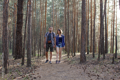 two tourists walking along a forest road