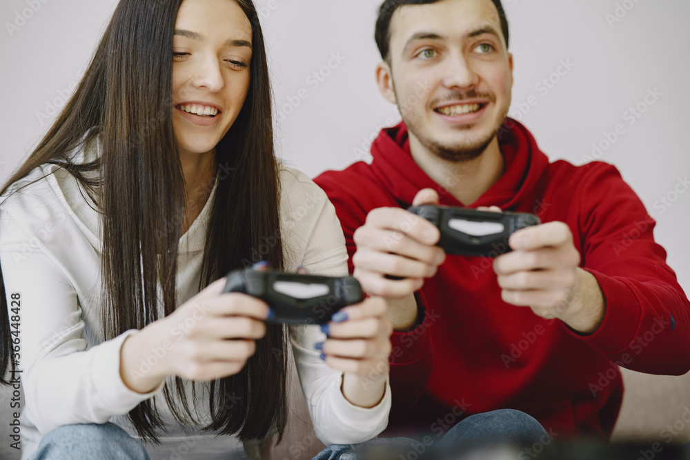 Couple with joysticks. People at home. Pair playing a video games. Couple with joysticks. People at home. Pair playing a video games.
