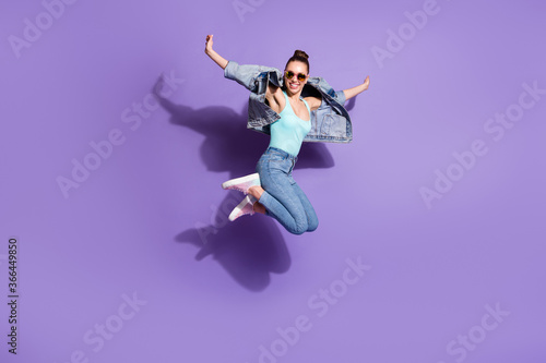 Full length photo of playful carefree youth girl jump enjoy weekend wear good look outfit sneakers isolated over violet color background