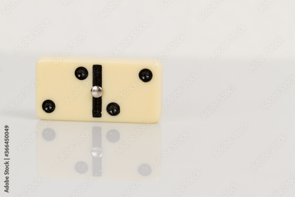 Close up of domino pieces with black dots isolated in white background with reflection