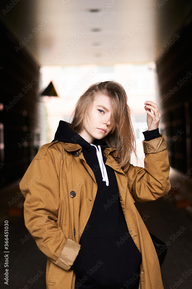 Beautiful blonde teenager girl with long hair in stylish orange
