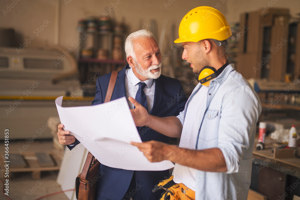 Architect and a woodworker having pleasant conversation about project Architect and a woodworker having pleasant conversation about project