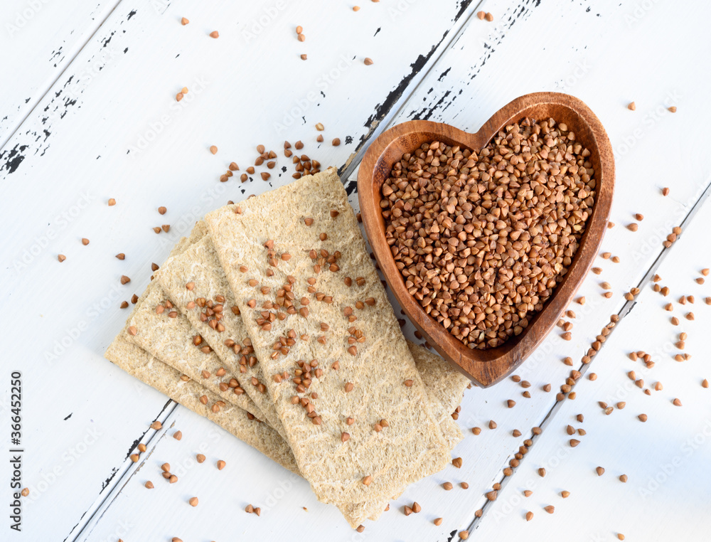 Dietary bread, Buckwheat cereal. Healthy crispbread for dieting and buckwheat on a light wooden background Dietary bread, Buckwheat cereal. Healthy crispbread for dieting and buckwheat on a light wooden background