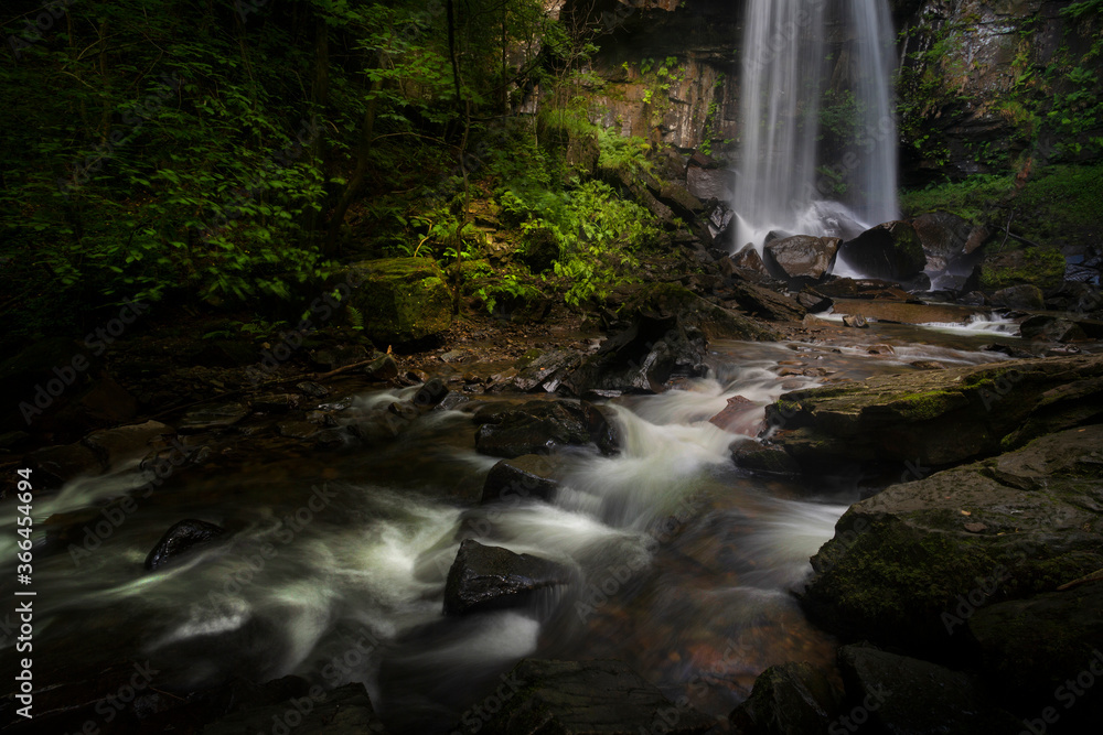 Obraz premium The moody and beautiful tall waterfall in Resolven, near Neath, South Wales, UK