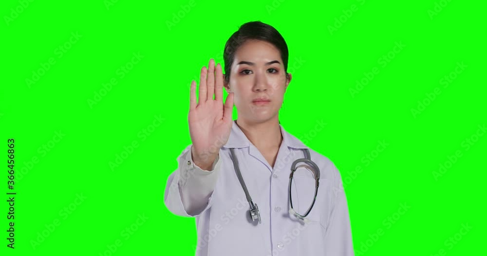 Female doctor rise her hand mean not approve with serous face at green screen background. Female doctor rise her hand mean not approve with serous face at green screen background.