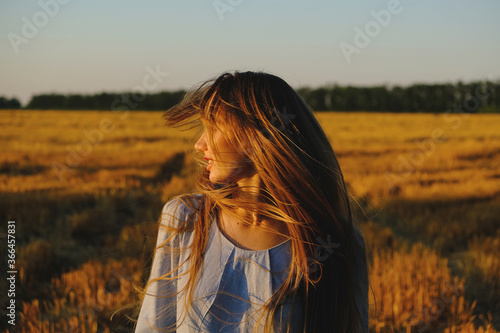 Digital Detox, Unplugging, Life, Offline, Sensitivity to nature, Mindfulness concept. Young blonde carefree wind long hair girl in blue linen dress enjoys life in the wheat field nature at sunset.