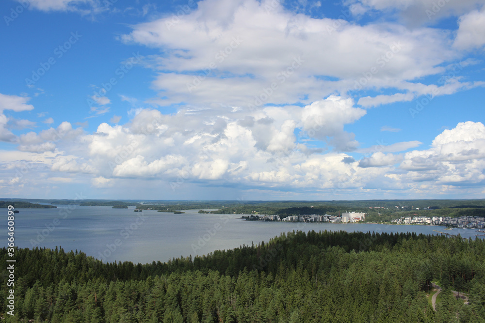 Top view of the forest and lake Vesijarvi against the sky with clouds. Lahti. Finland.