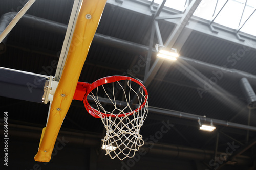 Basketball hoop in the sports center against the dark ceiling