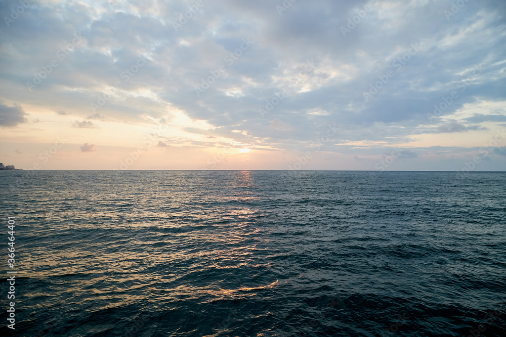 Water of sea and sky with clouds and sunset.