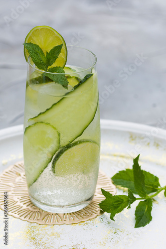 Refreshing drink - water with cucumber slices, ice cubes and fresh mint leaves.