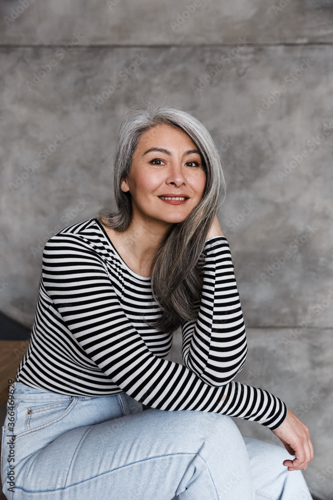 Photo of happy adult asian woman smiling and looking at camera Photo of happy adult asian woman smiling and looking at camera