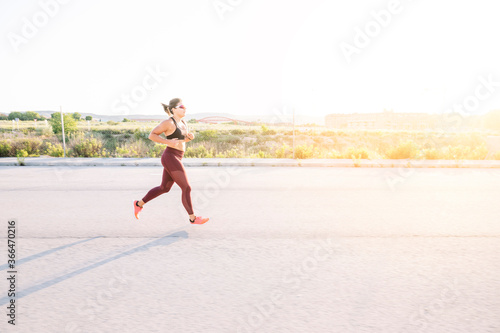 Athletic woman running in the street