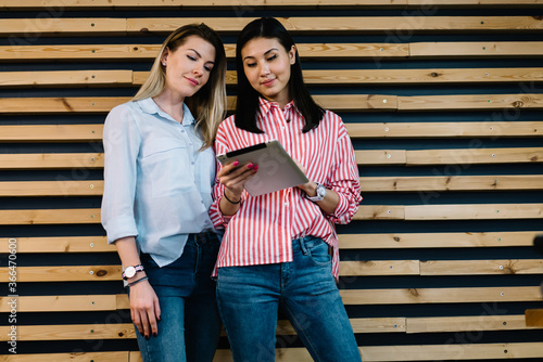 Confident multiethnic women with tablet browsing information