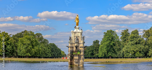 Diana Fountain in Bushy park, London.  Diana Fountain is a bronze statue of goddess on a marble and stone fountain, surrounded by bronzes of four boys, four water nymphs and four shells. photo